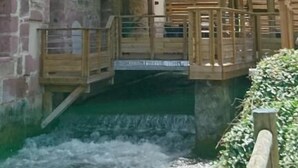 Une structure en bois à plusieurs niveaux, dotée de balcons donnant sur un canal.