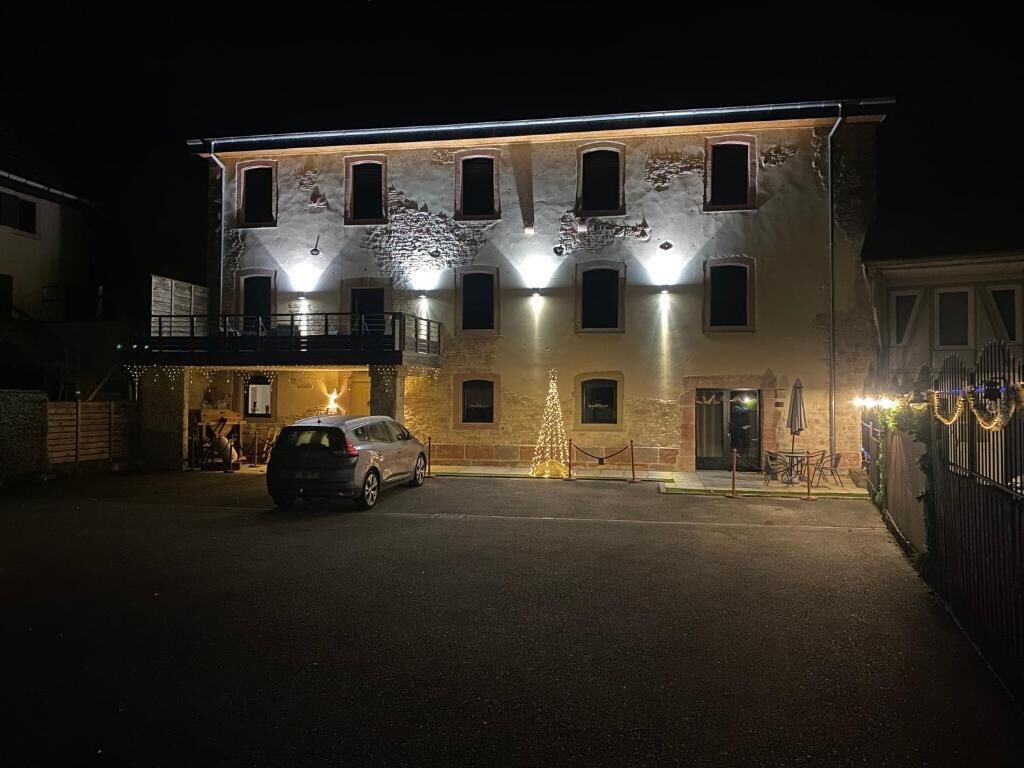 A building with multiple windows and a car parked in front.