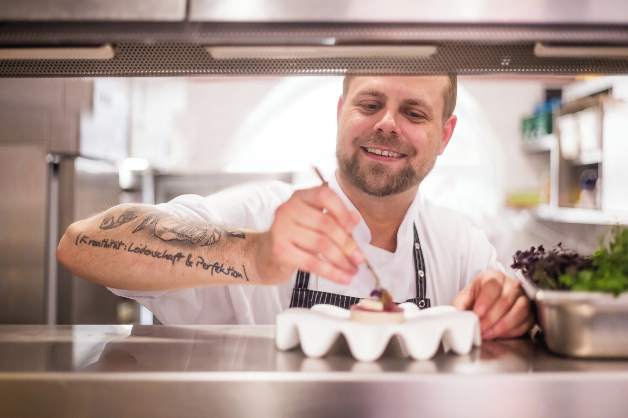 A chef in a professional kitchen with a focus on food preparation.