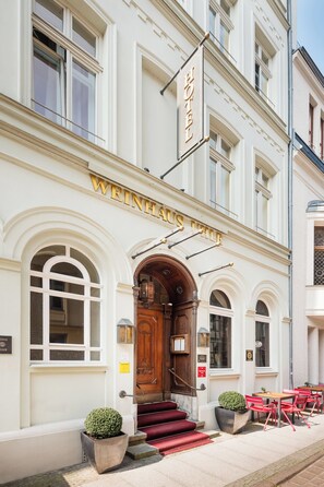 Un edificio con un letrero que dice "WEINHAUS LONDON" y una escalera que lleva a la entrada.