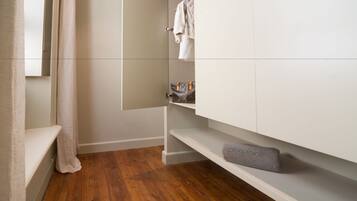 Un baño moderno con suelo de madera, tocador blanco y barra para toallas.