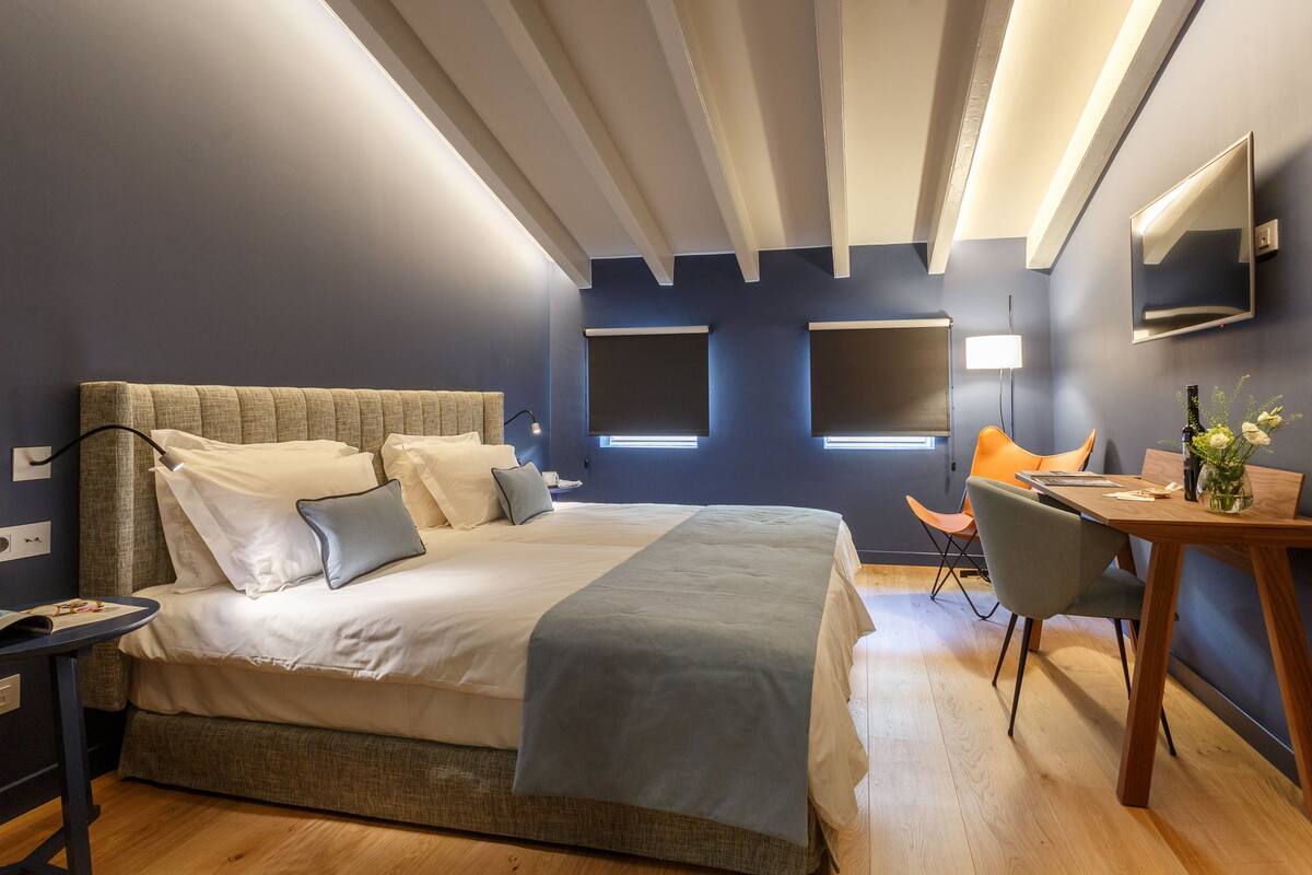 Een moderne hotelkamer met een groot bed, een bureau en een stoel.