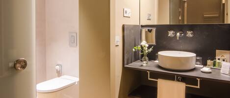 A modern bathroom with a toilet, sink, and mirror.