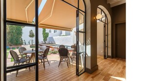 A wooden deck with outdoor furniture, a pool, and a covered area with a large umbrella. -  Bordoy Casa Ládico - Hotel Boutique Adults Only (Mahón)