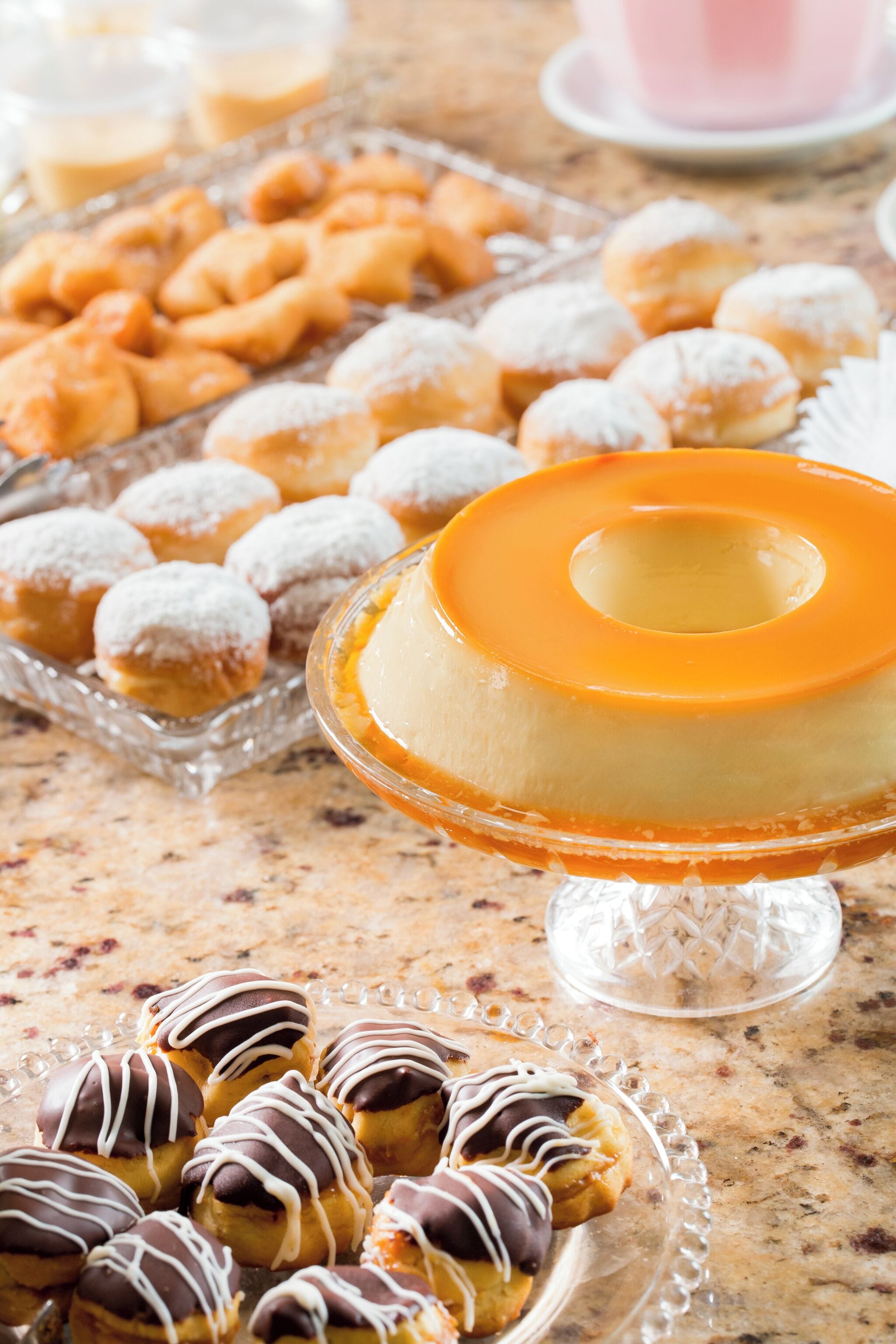 Une table de desserts avec divers pâtisseries et un flan au caramel.