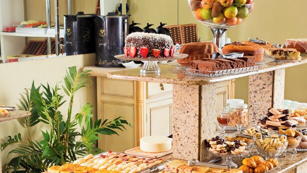 Un buffet proposant une variété de plats et agrémenté d’une plante décorative.