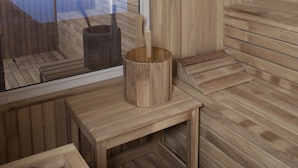 Uma sala de sauna de madeira com uma grande janela com vista para uma área de piscina.