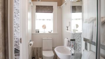 A bathroom with a toilet, bidet, and a glass shower enclosure.