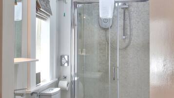 A modern bathroom with a glass-enclosed shower, a white sink, and a toilet.
