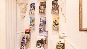 A display of travel brochures in a hallway with an arched ceiling and white walls. - Anvershiel House (Portrush)