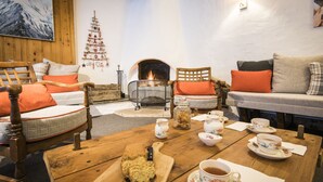 Una habitación acogedora con chimenea, muebles de madera y una mesa dispuesta para tomar té.