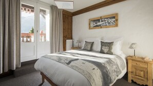 Un dormitorio con cama, mesita de noche de madera y un cuadro en la pared.