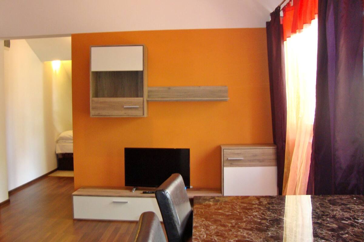 Een hotelkamer met een televisie, een bureau, een stoel en een bed.
