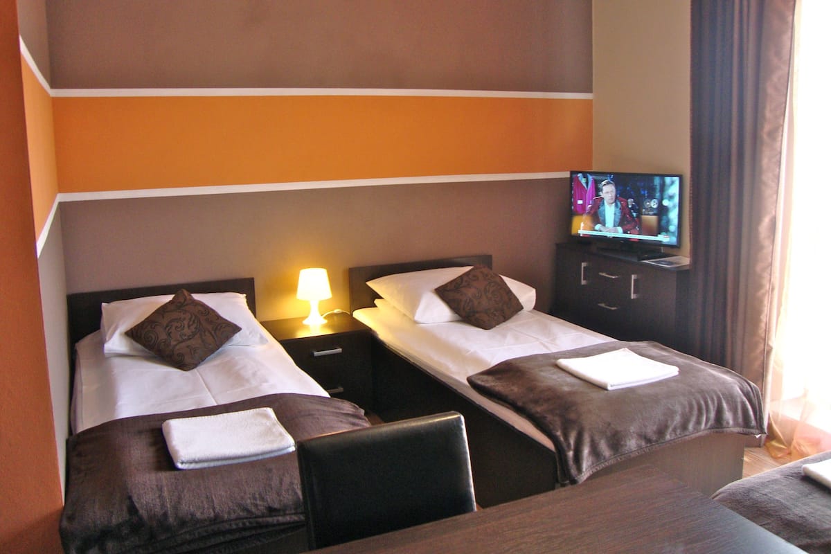 Een hotelkamer met twee bedden, een televisie en een bureau.