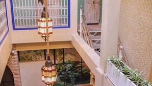 A multi-level indoor space with a central pool, seating areas, and hanging lights. - Riad 11 Zitoune (Marrakech)