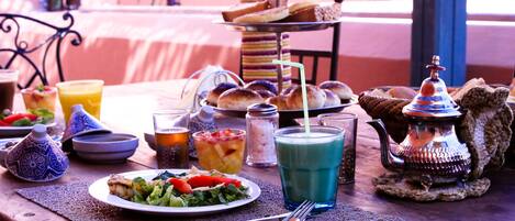Une table dressée avec différents plats, des boissons et une théière, ce qui laisse supposer qu’il s’agit d’un coin repas.