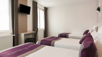 Een hotelkamer met twee bedden, een aan de muur bevestigde televisie en een bureau met een stoel.