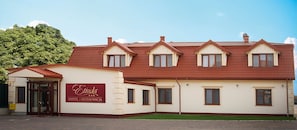 A two-story hotel with a red-tiled roof and a sign reading "Etida Hotel & Restaurant".