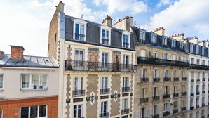 Una hilera de edificios de varios pisos con balcones, arquitectura europea clásica y un cielo despejado.
