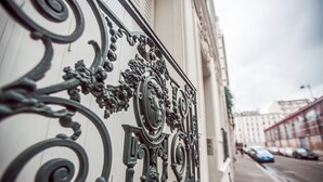 A wrought iron balcony railing with intricate designs and a clear view of the street below. - La Maison Gobert Paris Hotel Particulier (Paris)