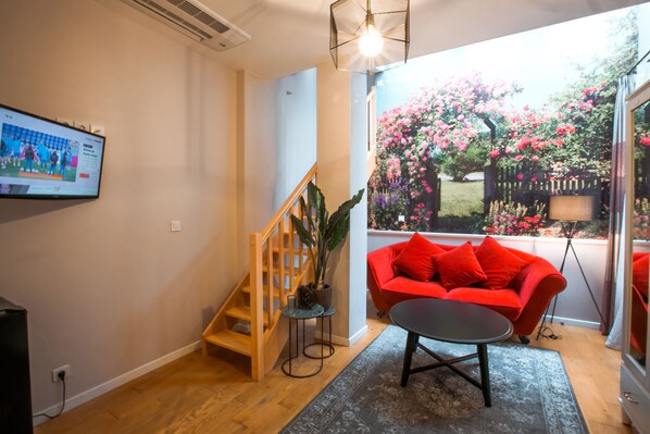 Una sala de estar moderna con un sofá rojo, una mesa de centro y una escalera.
