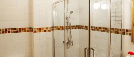 Un baño con ducha de vidrio, inodoro y lavamanos.