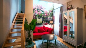 A living room with a wooden staircase, red sofa, and a cabinet. - La Maison Gobert Paris Hotel Particulier (Paris)