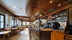 A restaurant with wooden interiors, a bar area, and seating arrangements. - Hotel Pezzotti (Pellizzano)