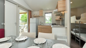 Una cocina compacta con comedor, refrigerador, estufa y lavamanos.
