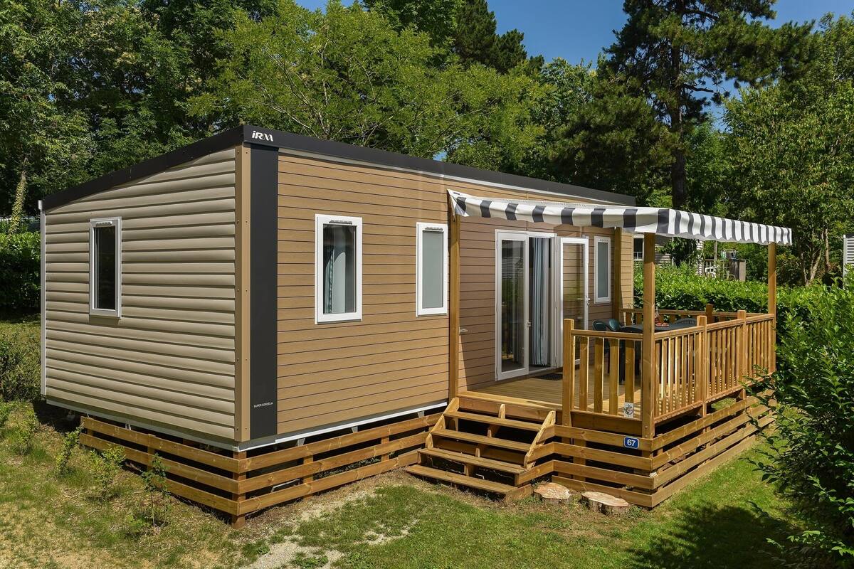 Een gelijkvloerse stacaravan met een terras en een overdekte patio.