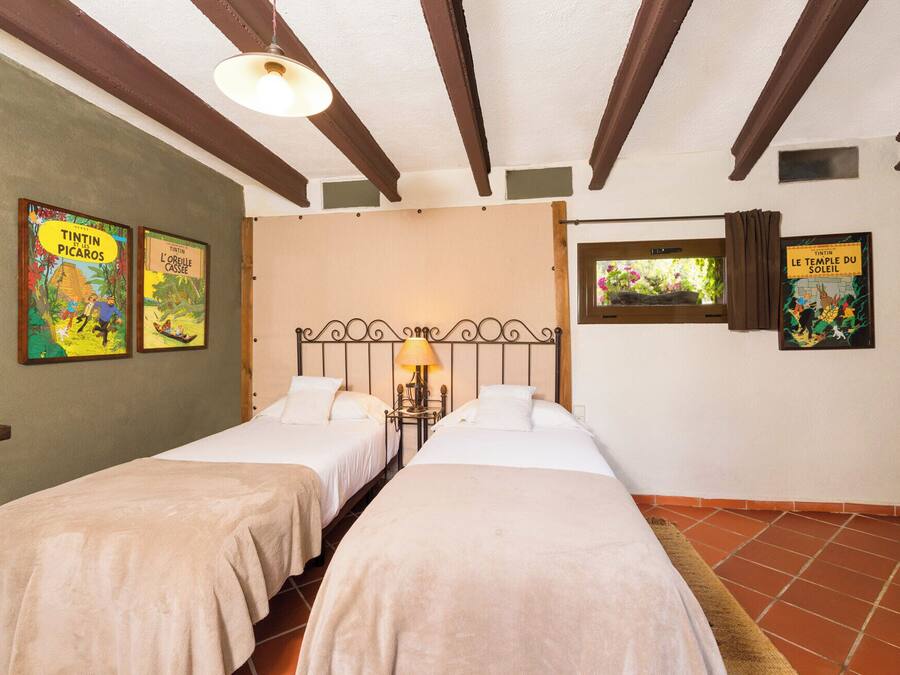 A room with two beds, a window with curtains, and wall art.