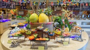Ein Buffet mit verschiedenen Speisen und tropischer Dekoration.