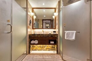 A bathroom with a vanity, mirror, towel rack, and a shower area. - Glory Charm Hotel (Fangchenggang)