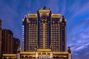 A high-rise hotel with multiple floors, large windows, and a prominent entrance. - Glory Charm Hotel (Fangchenggang)