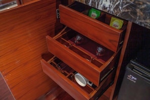 A wooden drawer unit with multiple compartments, including a lower drawer and two upper compartments, one of which contains a green packet. - Glory Charm Hotel (Fangchenggang)
