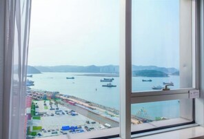 Vista desde una ventana sobre un puerto con barcos y un puerto deportivo.