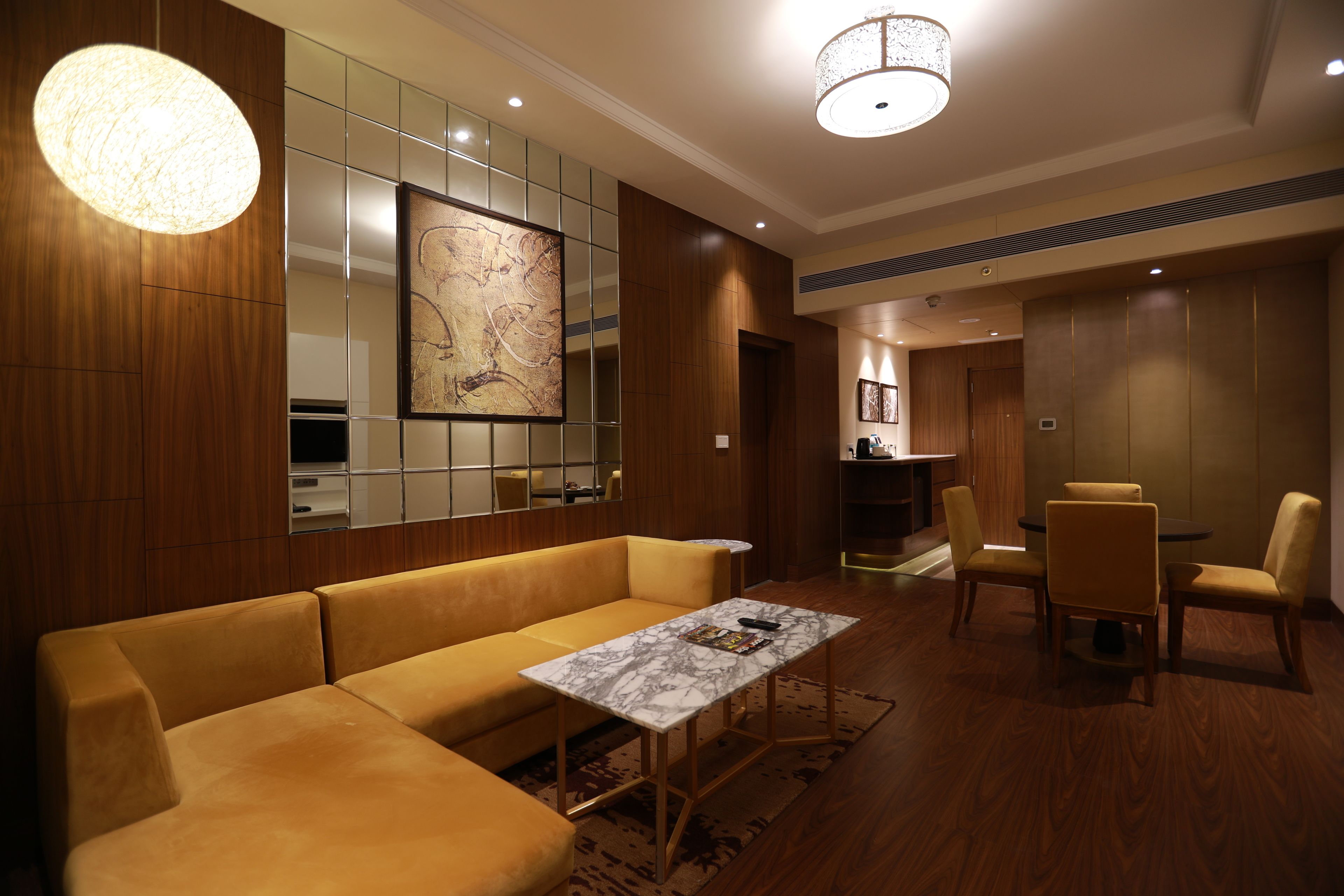 A modern hotel lobby with a sofa, a table, and chairs.