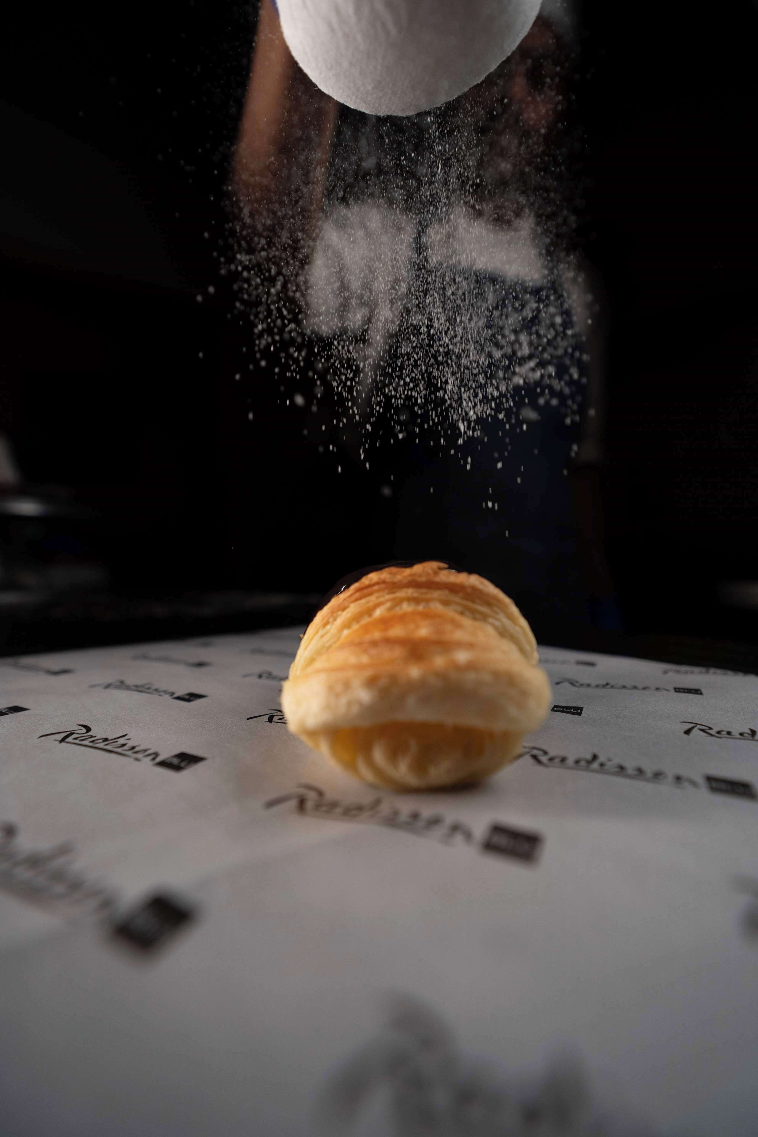 A croissant on a table with a pattern of text.