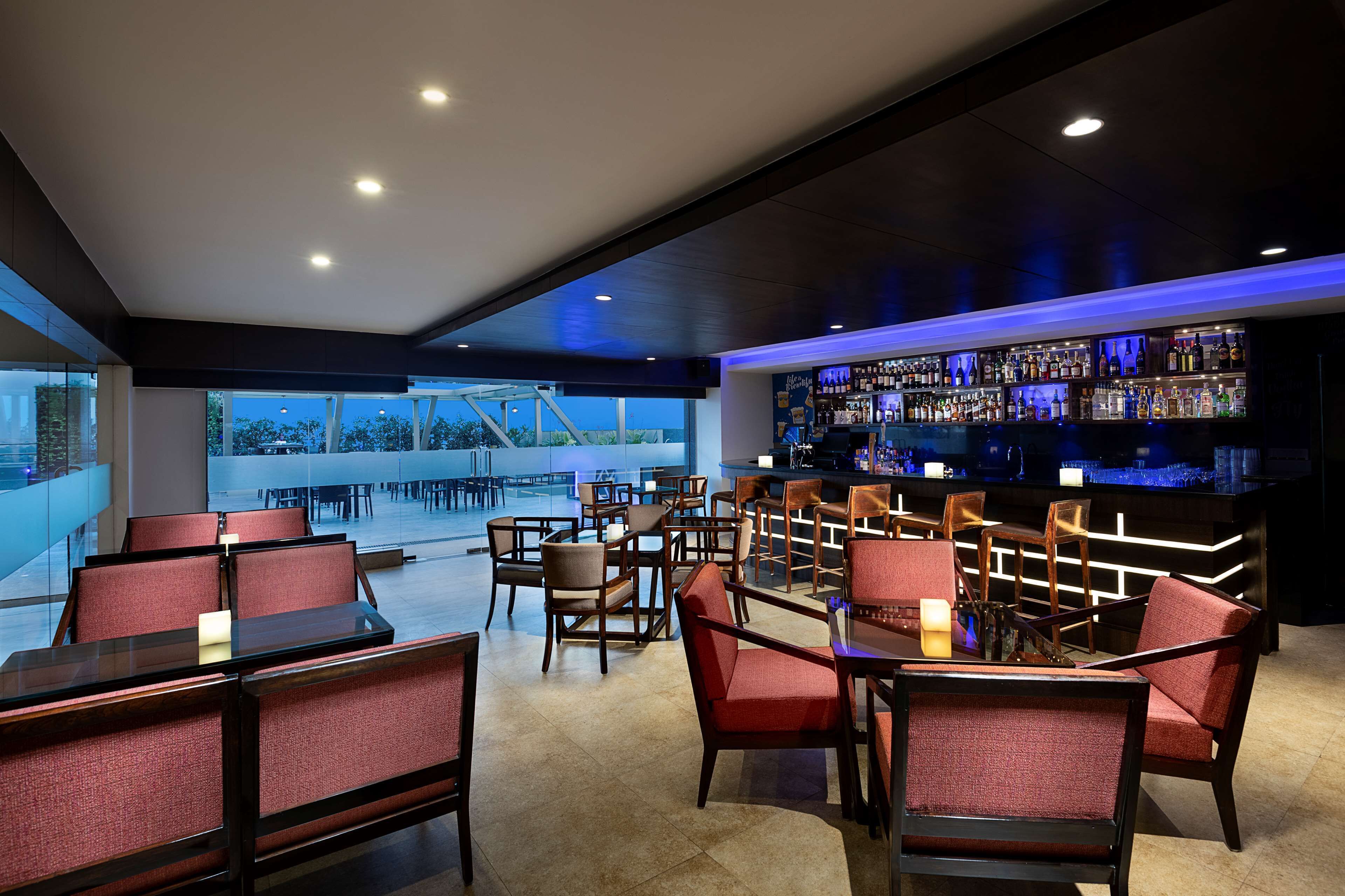 A bar area with seating and a view of the outdoors.