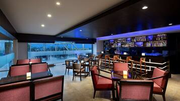 A bar area with seating and a view of the outdoors.