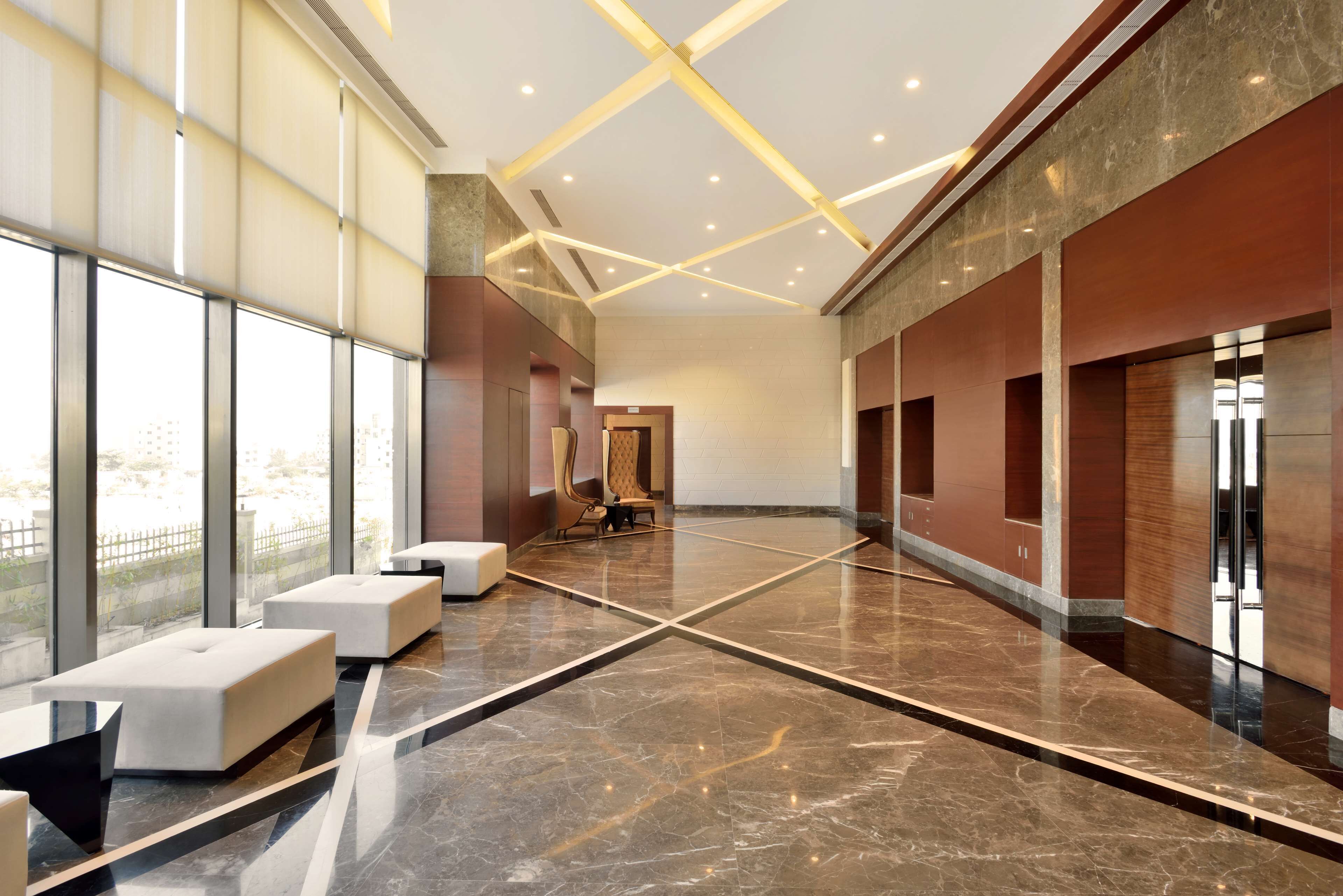 A spacious lobby with a high ceiling, large windows, and a modern design.