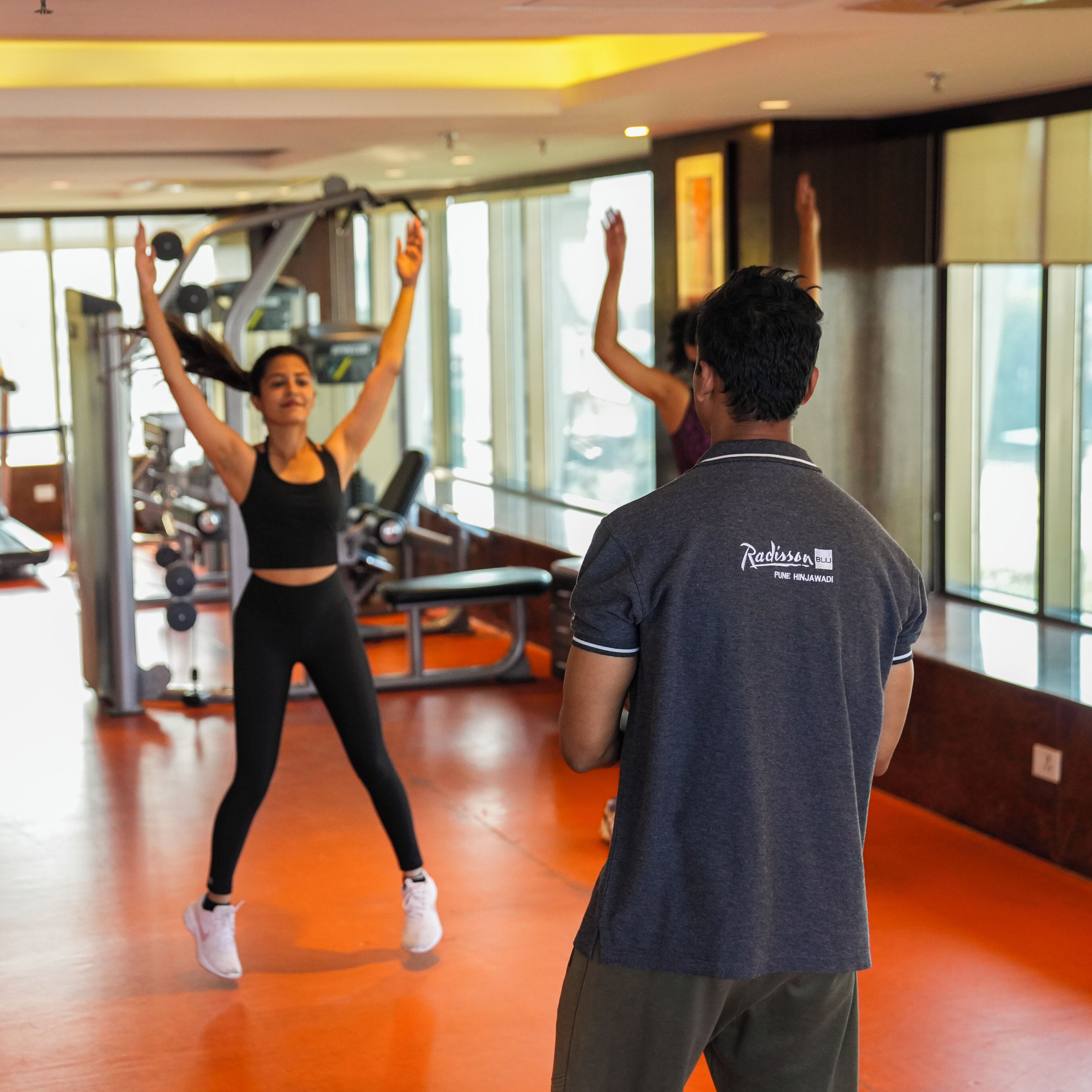 Ett gym med träningsutrustning och stora fönster.