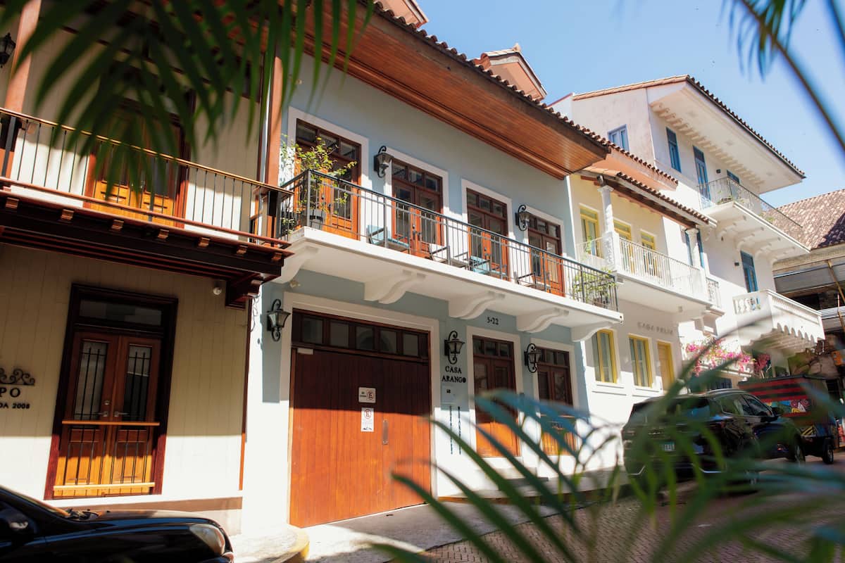 A multi-story building with balconies, wooden doors, and a sign indicating room number 5-22.