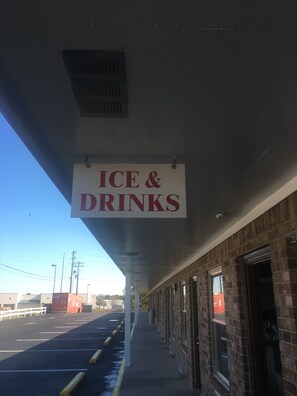A sign for 'ICE & DRINKS' hanging from a building's exterior.