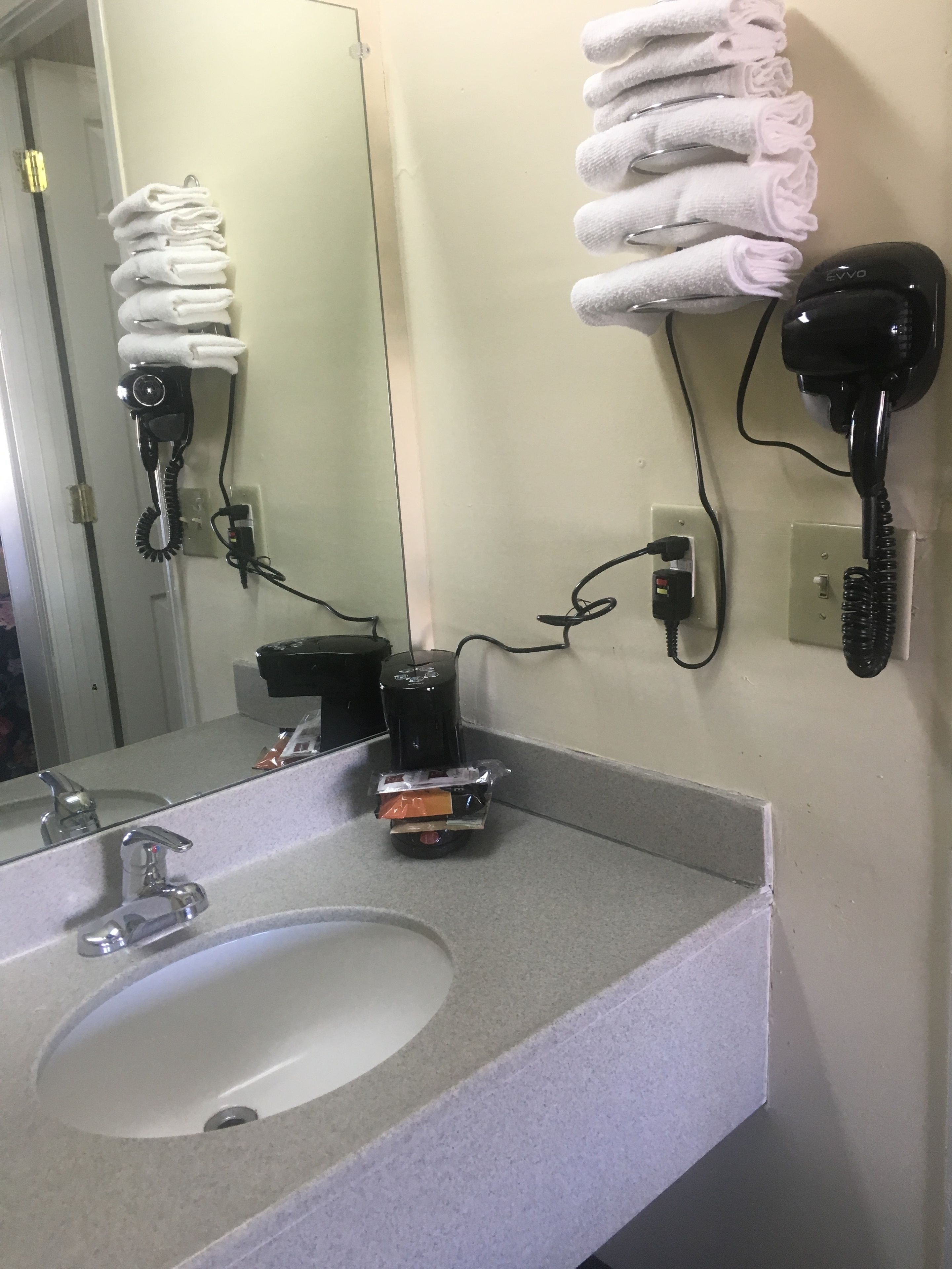 A bathroom with a sink, towel rack, and hair dryer.
