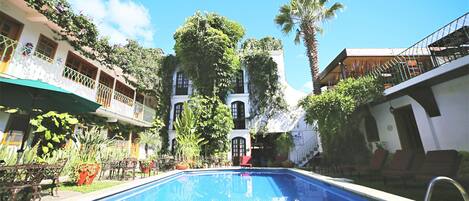 Een buitenzwembad, ligstoelen bij het zwembad