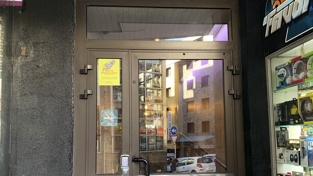 Entrada de hotel com uma placa indicando "RESIDENCIA SKY" e um teclado de segurança.