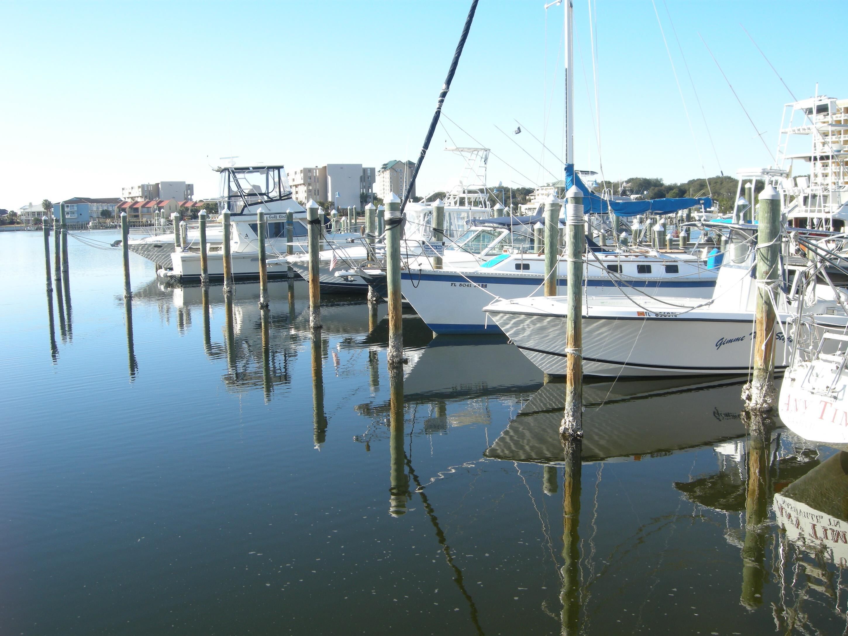 A marina with several boats docked at wooden pilings.