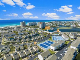 Zona residencial costera con un puerto deportivo, cancha de tenis y vista al océano.