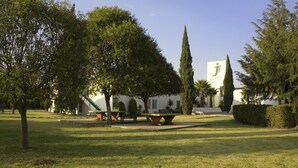 A courtyard with a lawn, benches, and a building with a sign reading "La Joya Hotel".